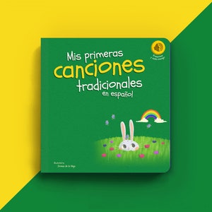 May include: A green book cover with the title "Mis primeras canciones tradicionales en español" and an illustration of a white rabbit peeking out of a grassy field with a rainbow in the background.