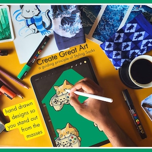 A photo of a man drawing the design for Novelty Gaming Cat Themed Socks in his creative studio