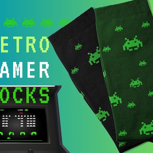 Puede incluir: Un par de calcetines con un diseño de videojuego retro. Los calcetines son negros y verdes con un patrón repetido de invasores espaciales verdes. El texto "RETRO GAMER SOCKS" se muestra en una fuente pixelada.