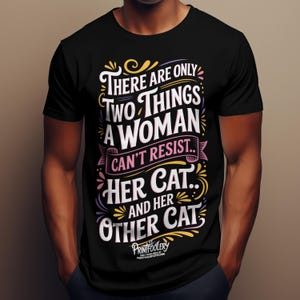 A man wearing a black t-shirt with colourful cat-themed typography on the chest.