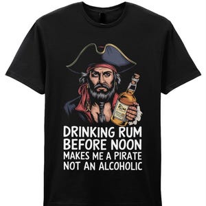 Peut inclure: T-shirt noir avec un pirate de dessin animé tenant une bouteille de rhum. Le texte sur le t-shirt est "Drinking rum before noon makes me a pirate not an alcoholic."
