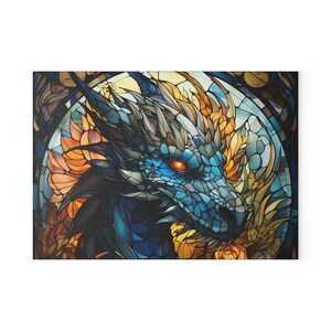 Op de afbeelding: Canvas print met een gedetailleerde illustratie van een drakenkop. De draak heeft blauwe schubben, vurige oranje en gele accenten en felrode ogen. Het kunstwerk doet denken aan glas-in-lood.