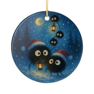 May include: Circular ceramic Christmas decoration. The image depicts fluffy black creatures in Santa hats, carrying lanterns in a snowy forest under a full moon. The ornament has a gold hanging string.