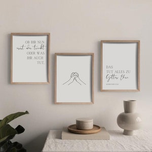 May include: Three framed prints with minimalist designs. The top print features a quote in German, the middle print shows a simple line drawing of two hands clasped together, and the bottom print features a quote in German with the text "DAS TUT ALLES ZU Gottes Ehre 1.KORINTHER 10:31".