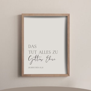 May include: A framed print with a white background and black text that reads "DAS TUT ALLES ZU Gottes Ehre. 1KORINTHER 10,31". The print is in a light wood frame and is available in A4 (21 x 29.7 cm) and A3 (29.7 x 42 cm) sizes.
