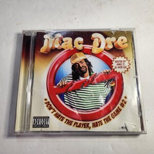 May include: A CD case featuring the album "Don't Hate the Player, Hate the Game #2" by Mac Dre. The cover art includes a portrait of the artist, a red prohibition sign, and the Parental Advisory Explicit Lyrics logo.