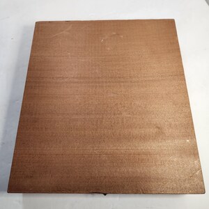 Puede incluir: Una tabla de madera rectangular de color marr&oacute;n claro con un patr&oacute;n de vetas de madera visible. La tabla es lisa y parece estar hecha de una sola pieza de madera. Los bordes son ligeramente redondeados.