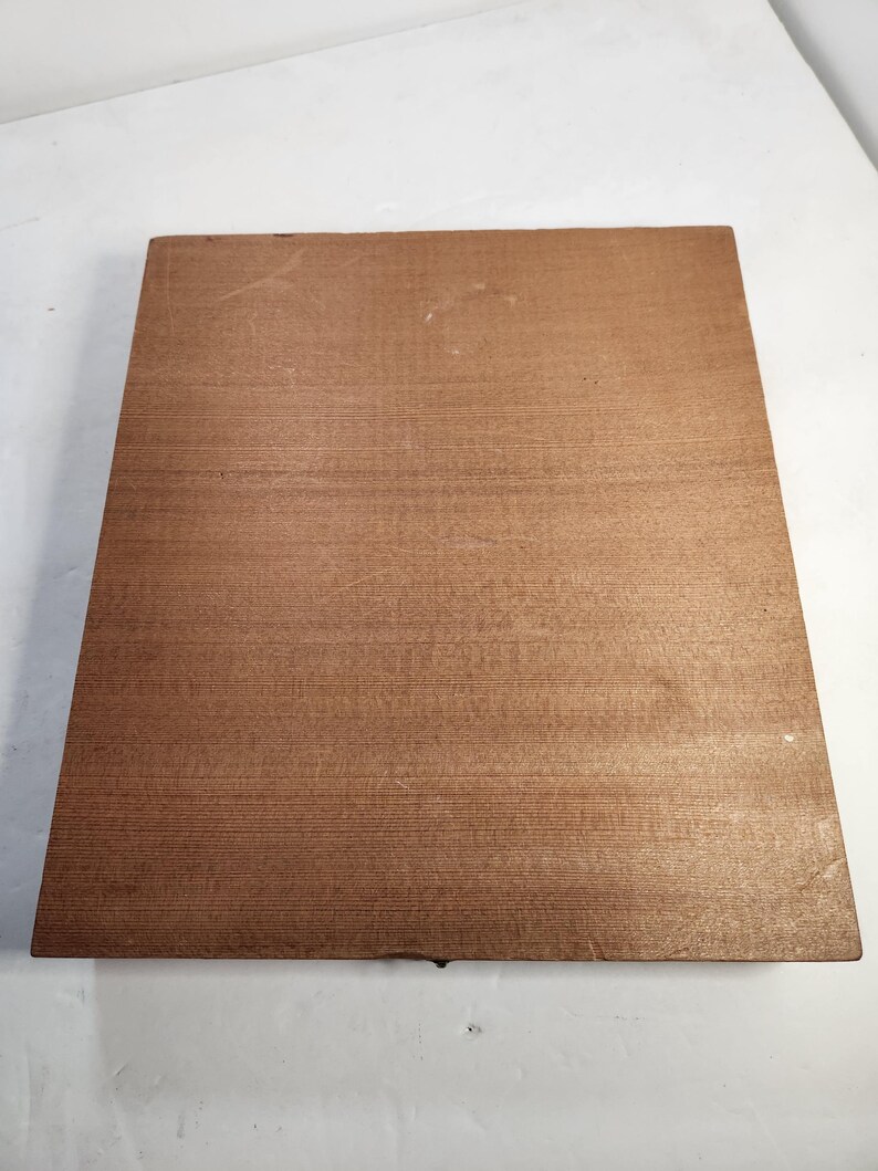 Puede incluir: Una tabla de madera rectangular de color marr&oacute;n claro con un patr&oacute;n de vetas de madera visible. La tabla es lisa y parece estar hecha de una sola pieza de madera. Los bordes son ligeramente redondeados.