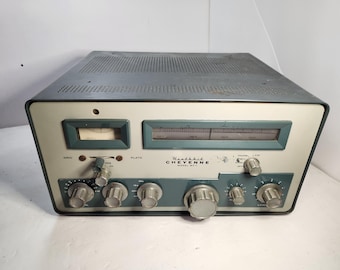 May include: Vintage Heathkit Cheyenne Model MT-1 radio receiver. The radio has a light gray and teal color scheme with multiple dials, gauges, and a speaker grill on top. The text "Heathkit Cheyenne Model MT-1" is visible.