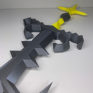 May include: A 3D printed black and yellow scorpion with a curved tail and a stinger. The scorpion is posed with its claws raised.