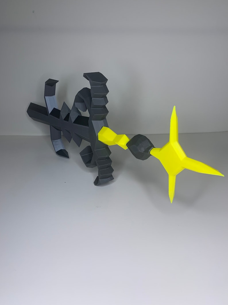 May include: A black and yellow 3D printed sword with a star-shaped tip. The sword has a detailed design with a textured surface.