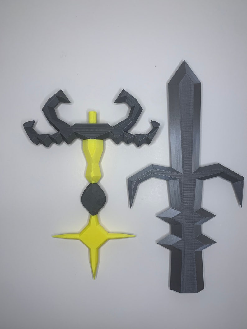 May include: Two 3D printed weapons, one yellow and one gray. The yellow weapon has a scorpion-like design with a star-shaped tip. The gray weapon is a sword with a pointed tip and a decorative design.