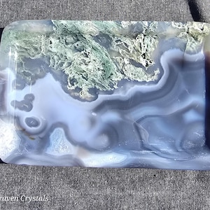 May include: Rectangular tray with a polished surface. The tray features a swirling pattern of blue, gray, and white, with areas of green. The text "Craven Crystals" is visible on the bottom left corner. The tray has rounded corners.