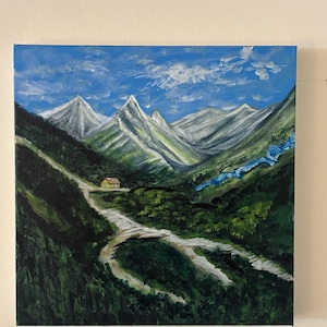 May include: An acrylic painting of a mountain landscape. The artwork depicts snow-capped mountains under a blue sky with white clouds. A winding road leads to a small yellow house nestled in a valley, with a blue river flowing nearby.