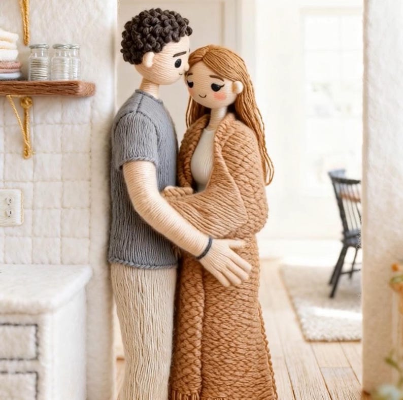 May include: A yarn doll couple in an embrace, crafted with meticulous detail. The male doll is dressed in a grey top and beige trousers, the female doll in a brown shawl. The scene evokes warmth and intimacy, set in a domestic environment, suggesting a theme of love and togetherness.