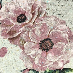 Puede incluir: Primer plano de una impresi&oacute;n floral rosa y blanca sobre un fondo de tela texturizada. Las flores tienen un aspecto delicado y descolorido y est&aacute;n acentuadas con purpurina.