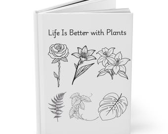 Può includere: Un diario bianco con la scritta "Life Is Better with Plants" e disegni a tratto nero di varie piante e fiori, tra cui una rosa e un giglio. Il diario è aperto, rivelando pagine bianche.