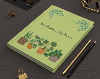 Könnte beinhalten: Ein hellgrünes Notizbuch mit dem Text "My Plants, My Peace" und Illustrationen von Topfpflanzen. Gold- und schwarze Bleistifte sowie goldene Büroklammern sind ebenfalls zu sehen.