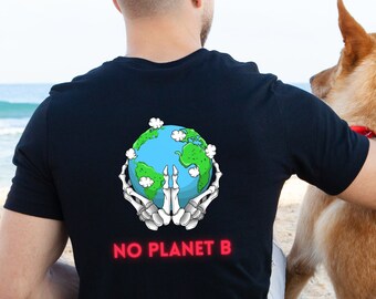 May include: A black t-shirt with a graphic of a skeleton hand holding a globe with the text "NO PLANET B" printed on the back. The person wearing the shirt is sitting on a beach with a dog.