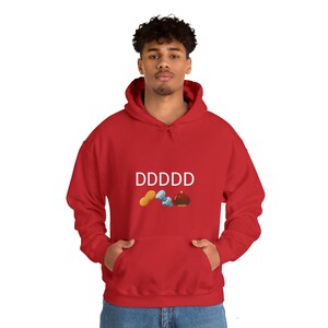 Könnte beinhalten: Roter Kapuzenpullover mit einer weißen Grafik, auf der "DDDDD" steht und ein Erdnuss, eine Schraube und ein brauner Hut abgebildet sind.