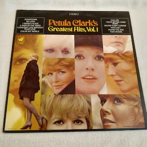 Peut inclure: Pochette de l'album Petula Clark's Greatest Hits, Vol. 1. La couverture présente un collage d'images de Petula Clark, avec des titres de chansons comme "Downtown" et "My Love". Un disque vinyle vintage.
