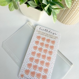May include: A sheet of stickers with 28 pink heart-shaped cake icons with the text "Happy Birthday" on each. The sheet has a white background with a confetti pattern of pink, blue, and green sprinkles. The text "birthdays" is at the top of the sheet. The text "EVERY GOOD AND PERFECT GIFT IS FROM ABOVE JAMES 1:17" is below the icons. The text "X 28 icons = Goals = GRACEFULLY SEEKING" is at the bottom of the sheet.
