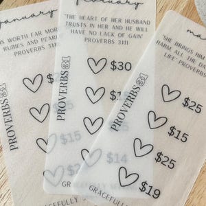 May include: Three white cards with black text and hearts. The cards are labeled "January", "February", and "March". Each card has a Bible verse and a price. The January card says "Is worth far more rubies and pearls" Proverbs 3:11. The February card says "The heart of her husband trusts in her and he will have no lack of gain" Proverbs 3:11. The March card says "She brings him harm, all the days of his life" Proverbs 31:11.