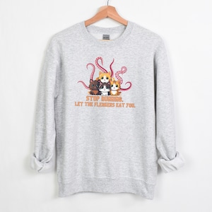 May include: Gray sweatshirt with a graphic of four cartoon cats surrounded by pink octopus tentacles. The text "STOP RUNNING. LET THE FLERKENS EAT YOU." is printed below the cats.