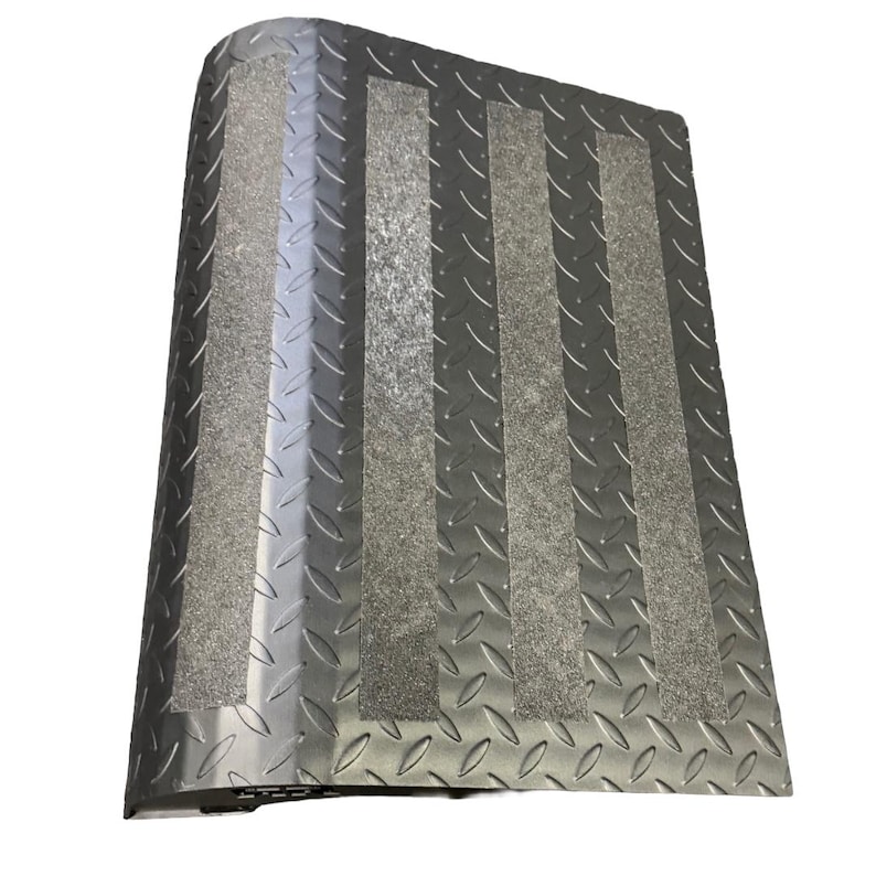 May include: A silver metal ramp with a diamond plate pattern and three gray, textured strips for traction. The ramp has a curved edge and is designed for accessibility.