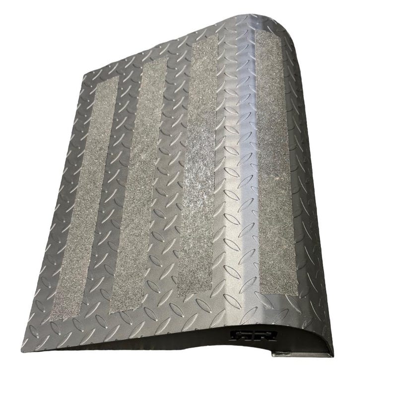 May include: A silver metal ramp with a diamond plate pattern and three gray, textured strips. The ramp has a curved edge and a black base, designed for accessibility and safety.