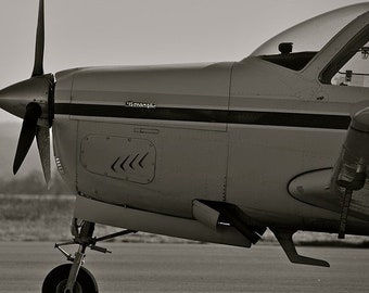 May include: A black and white photo of a small, single-engine airplane with a propeller. The plane is on the ground and the word "remarkable" is visible on the side of the plane.