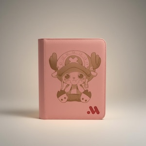 May include: A pink binder featuring a cartoon character with large eyes, wearing a hat with antlers. The character is in a seated position with hands near the face. A red "M" logo is in the lower right corner.