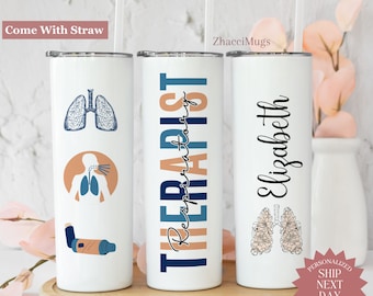 May include: Three white stainless steel tumblers with straws. One tumbler has a blue lung illustration, another says "Respiratory Therapist", and the third says "Elizabeth". The tumblers are on a wooden tray.