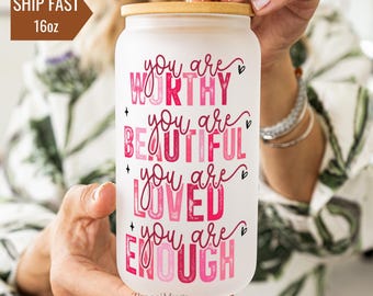 May include: White tumbler with a wooden lid and a pink and white design that says "You are worthy, You are beautiful, You are loved, You are enough".