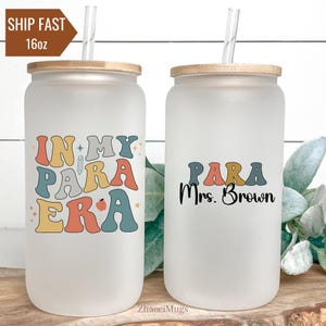 May include: Two 16oz frosted glass tumblers with lids and straws. One tumbler has the text "In My Para Era" in colorful letters with a pencil and apple graphic. The other tumbler has the text "Para Mrs. Brown" in colorful letters.