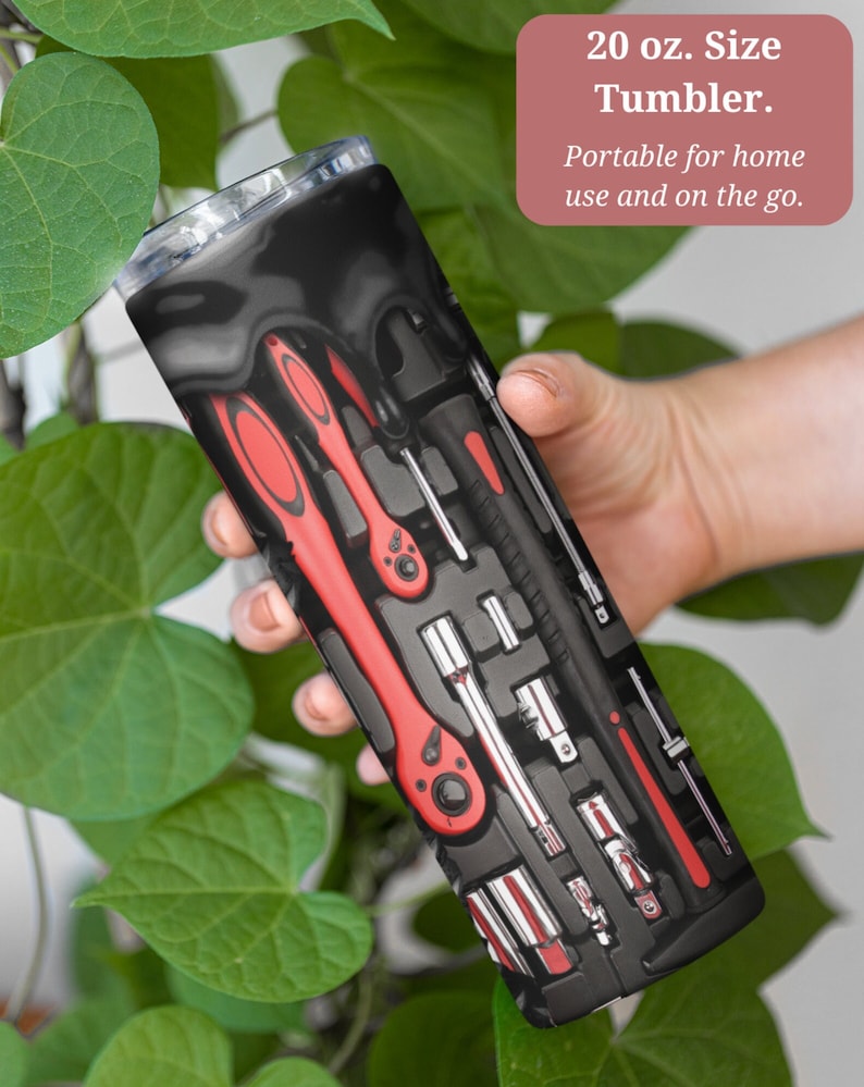 Op de afbeelding: Een zwarte en rode 20 ounce roestvrijstalen tumbler met een ontwerp van gereedschap in een gereedschapskist. De tekst "20 oz. Size Tumbler. Portable for home use and on the go." is op de tumbler gedrukt.