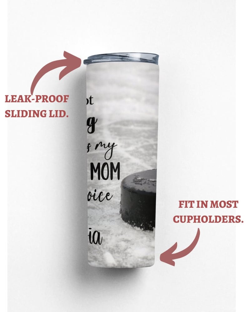 May include: White stainless steel tumbler with a black hockey puck and the text "Not my mom's choice" on a white background. The tumbler has a leak-proof sliding lid and fits in most cupholders.