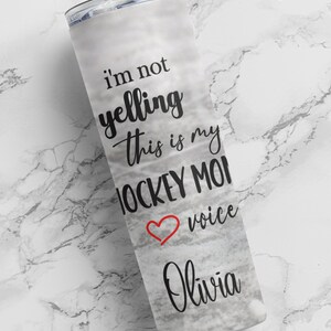 May include: White tumbler with a black and red design that says "I'm not yelling this is my hockey mom voice Olivia".