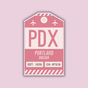 May include: Pink luggage tag with white text that reads "PDX PORTLAND OREGON EST. 1936 OR-97218". The tag has two airplane icons at the top and a white stripe pattern at the bottom.