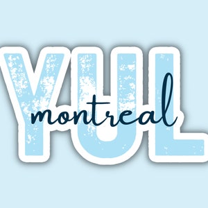 May include: A light blue sticker with the text "YUL montreal" in a distressed font. The word "YUL" is in a larger, blocky font, and "montreal" is in a cursive font. The sticker has a white border and is set against a light blue background.