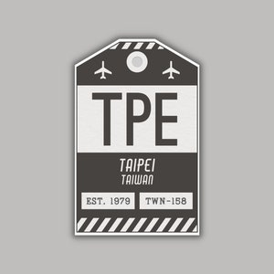 May include: Black and white airport luggage tag with the code TPE, the words Taipei Taiwan, EST. 1979, and TWN-158.