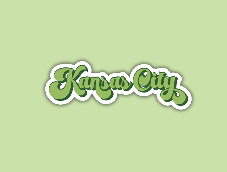K&ouml;nnte beinhalten: Ein gr&uuml;ner und wei&szlig;er Aufkleber mit dem Text "Kansas City" in einer Retro-Schrift.