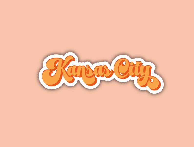 K&ouml;nnte beinhalten: Ein Aufkleber im Retro-Stil mit dem Text "Kansas City" in orangefarbener Schrift mit wei&szlig;em Umriss.