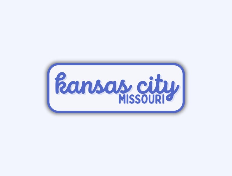 May include: A rectangular sticker with rounded corners, featuring the words "kansas city" in blue cursive script above "MISSOURI" in a smaller, sans-serif font. The text is set against a white background with a blue border.