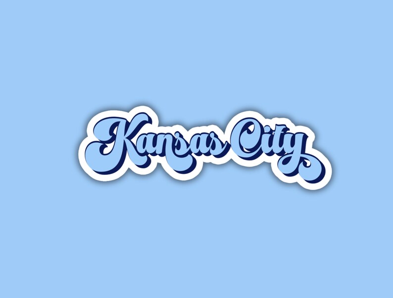 K&ouml;nnte beinhalten: Ein blauer und wei&szlig;er Aufkleber mit dem Text "Kansas City" in einer Retro-Schrift.