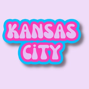 May include: A blue and pink retro-style graphic with the text "KANSAS CITY" in bubble letters.