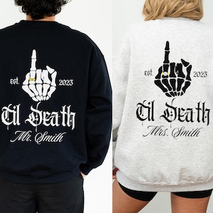 May include: Black and gray sweatshirts with a skeleton hand design. The design includes a ring, the text "est. 2023", and "Til Death Mr. Smith" on one, and "Til Death Mrs. Smith" on the other. A unique wedding or anniversary gift.