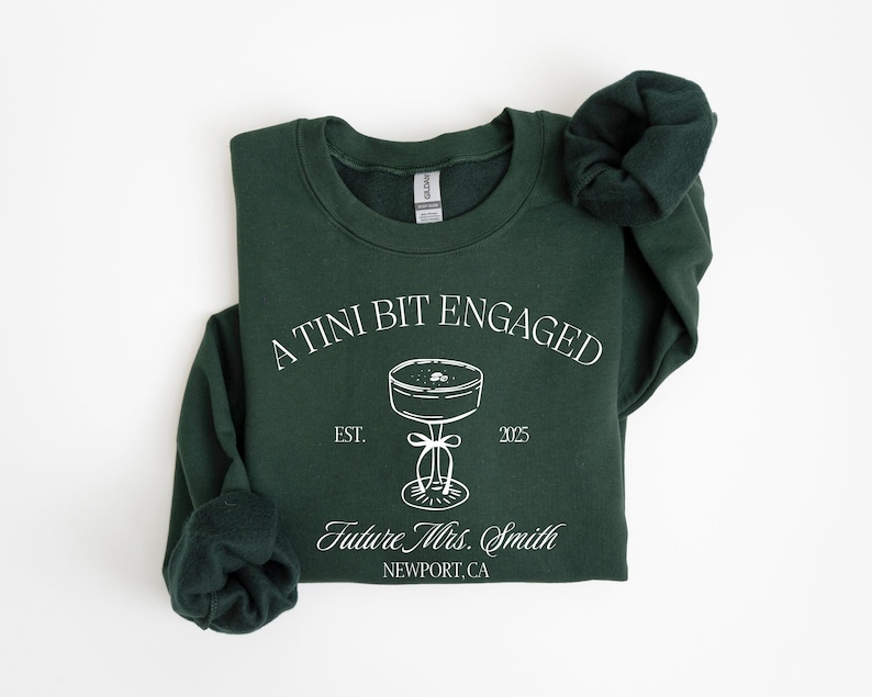 A dark green sweatshirt with white text and graphics printed on it.