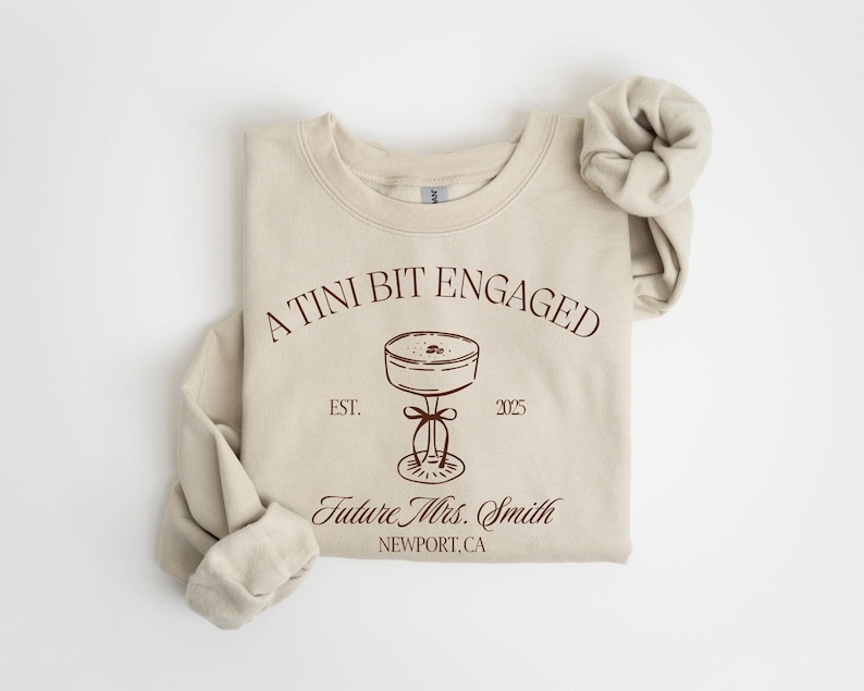 A beige sweatshirt with a graphic design and text printed on it.