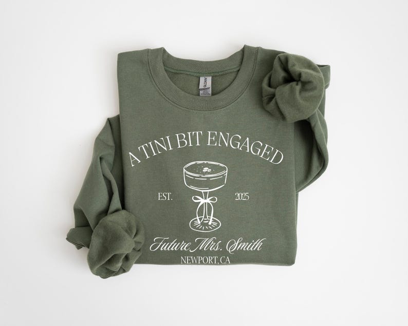 A green sweatshirt with white text and graphics printed on it.